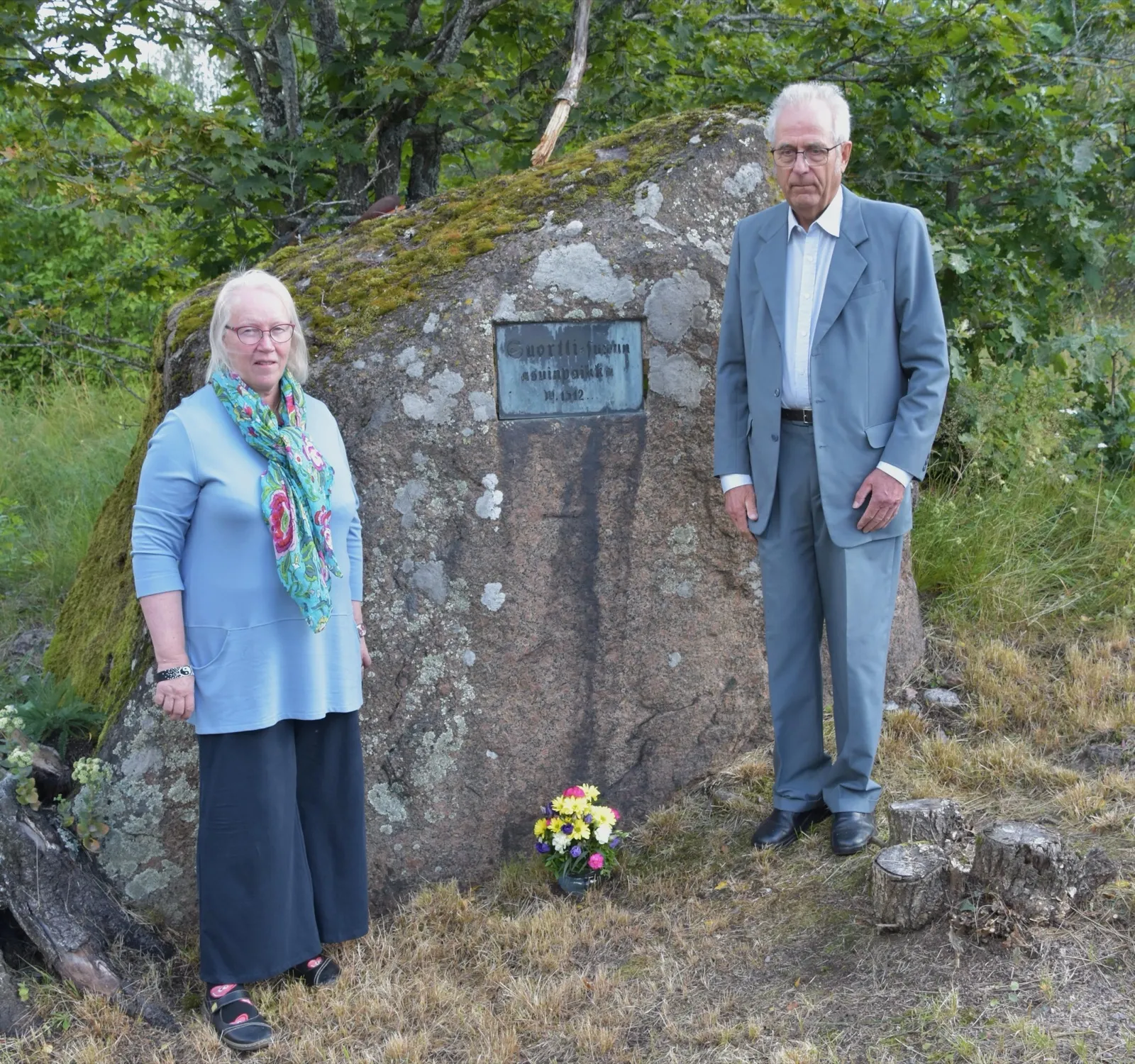 Risto Kihula ja Päivi Suortti Sukukivellä kukkakimpun kanssa